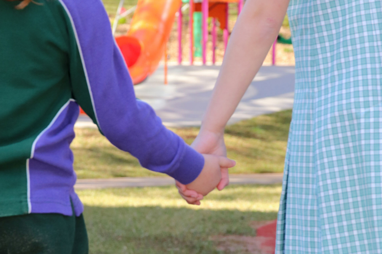 Two students holding hands