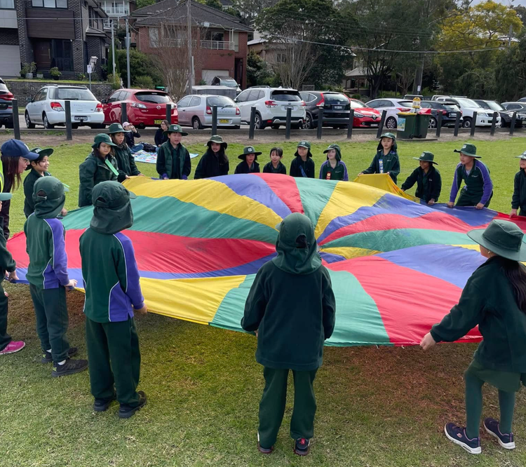 Group of students at the park doing a parachute activity